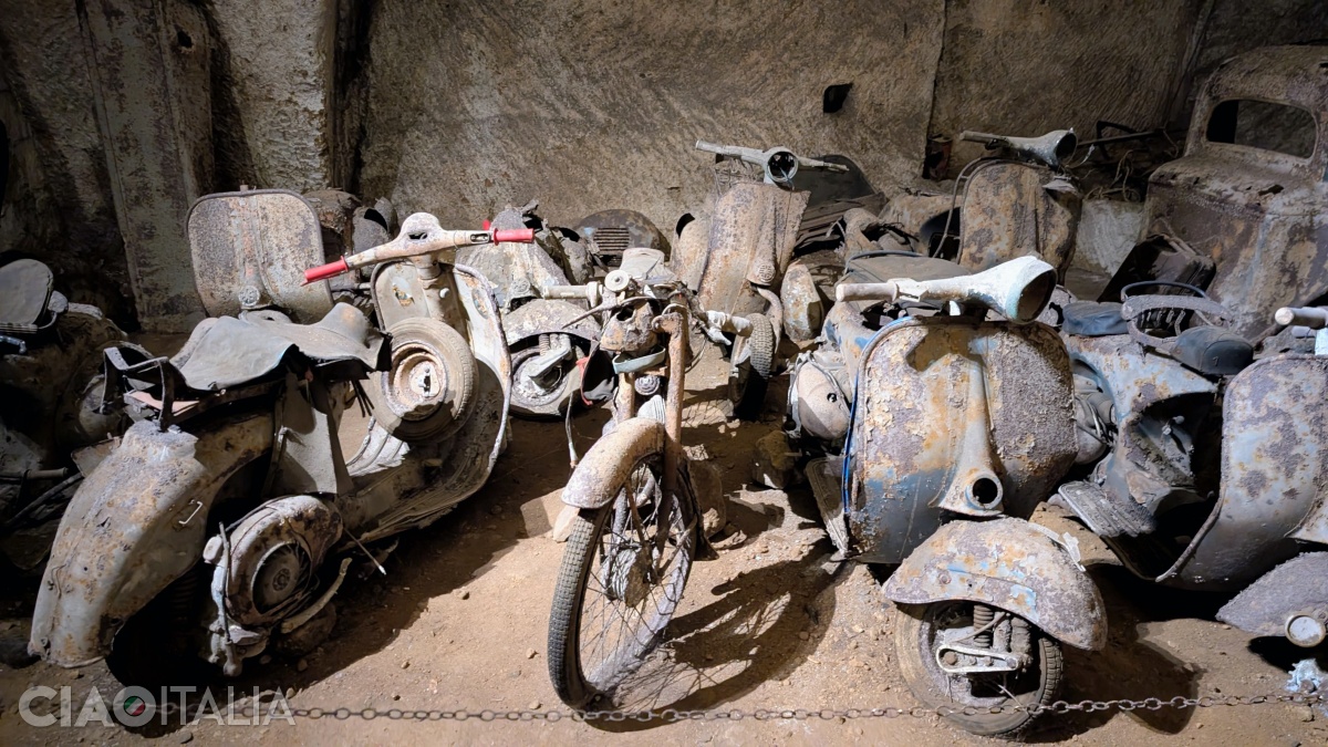 Pe lângă mașini, poți vedea și mai multe motociclete și scutere vechi.