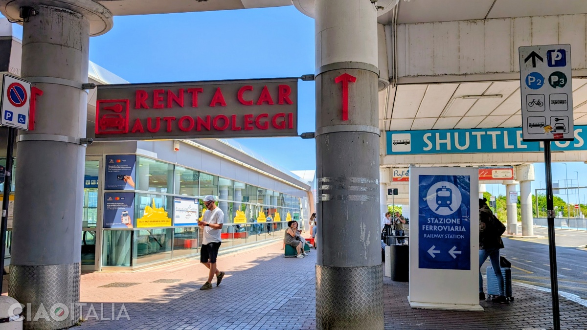 Pentru a ajunge la parcarea de rent a car, urmează drumul dintre gară și stația de shuttle bus.